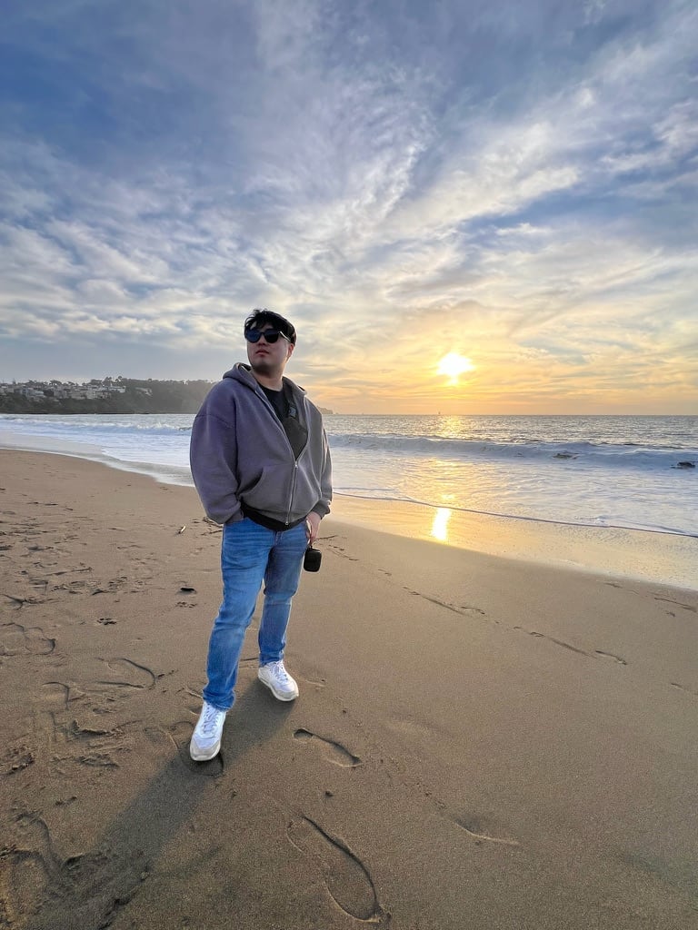 Chris standing on a beach at sunset